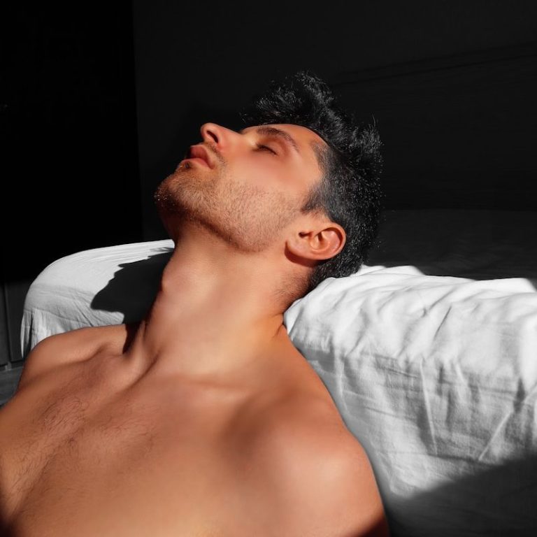 Man with bare chest, lying relaxed, face turned towards the light